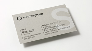 明るいグレー色の紙に白印刷＋黒印刷の名刺